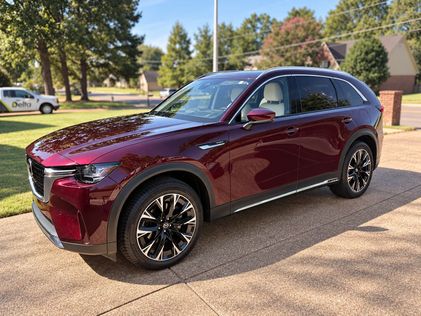 A maroon Mazda CX-90 with a freshly applied ceramic coating gleaming on a driveway
