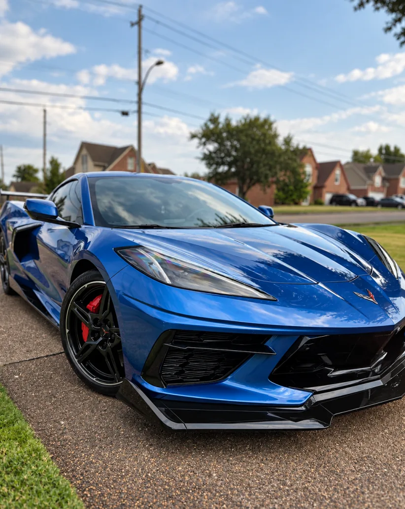 A blue C8 Chevrolet Corvette with a ceramic-coated finish on a driveway