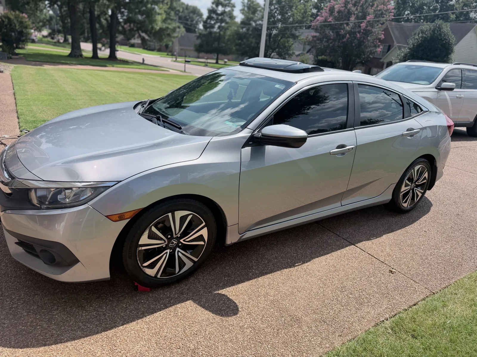 A silver Honda Civic after an exterior detail on a driveway