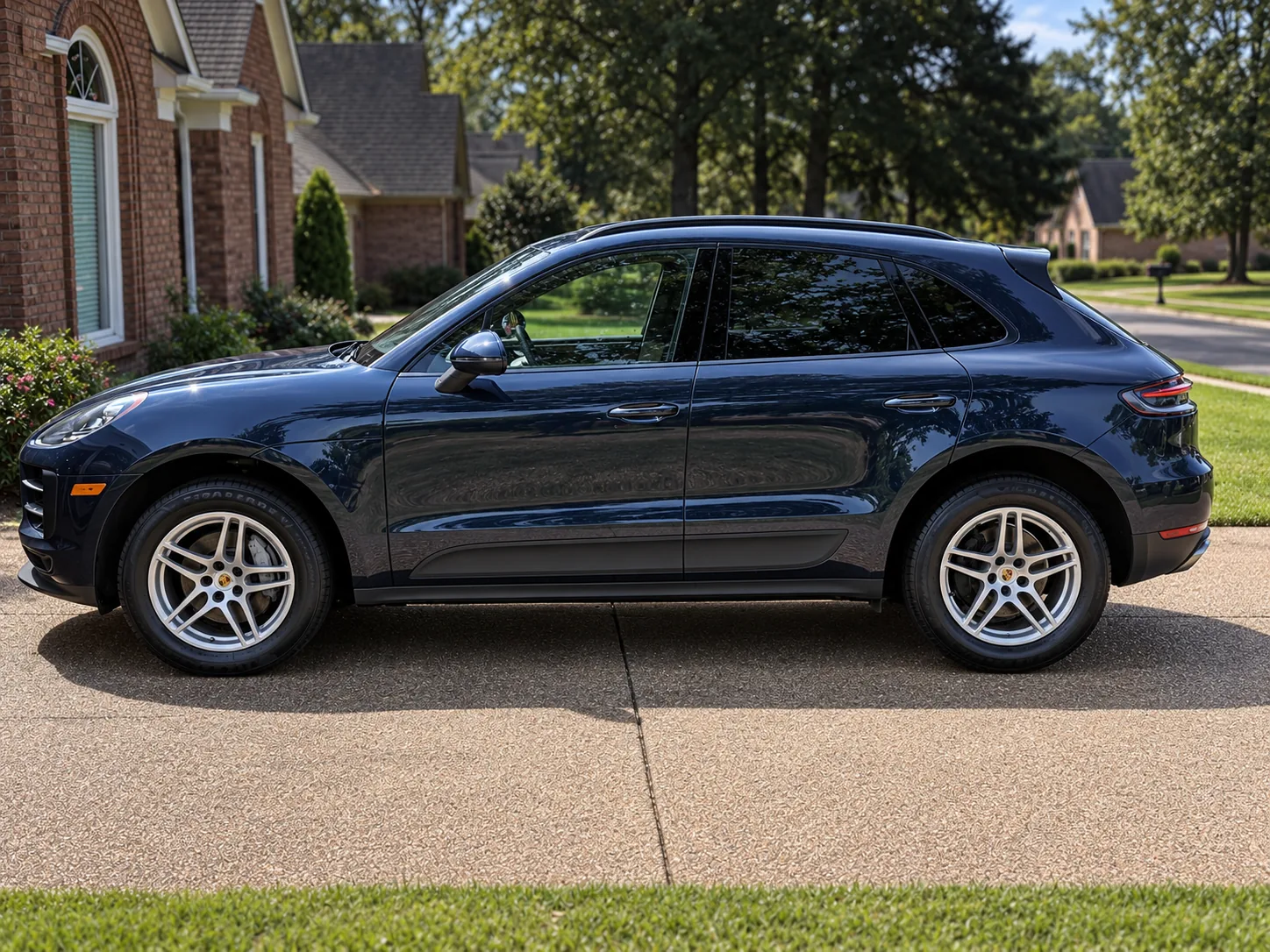 A dark Porsche SUV detailed to a deep gloss