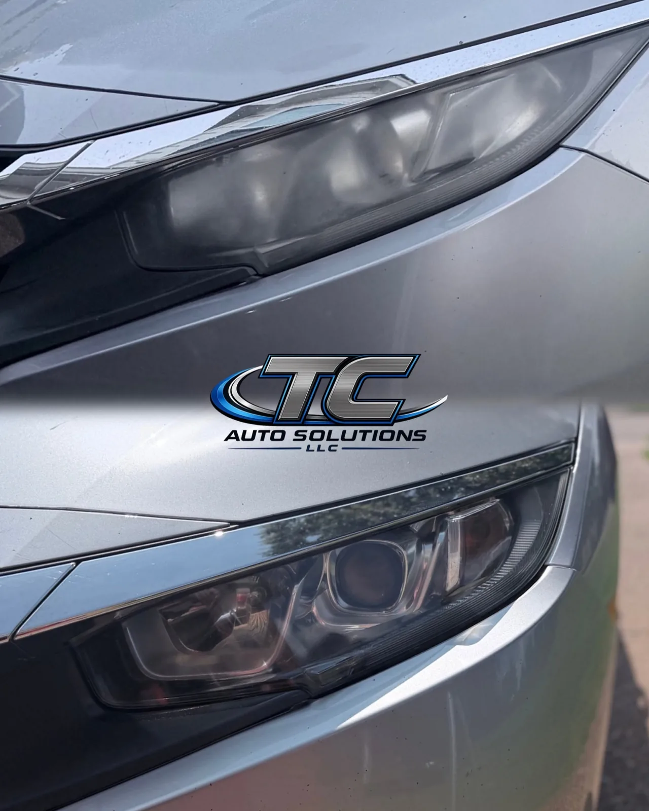 A headlight restored to a clear, glossy finish, with the TC Auto Solutions logo