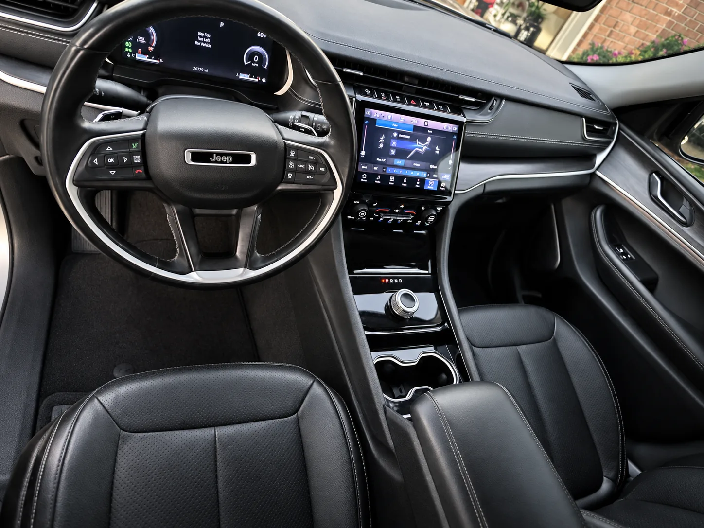 A detailed Jeep interior with clean black leather seats and dashboard